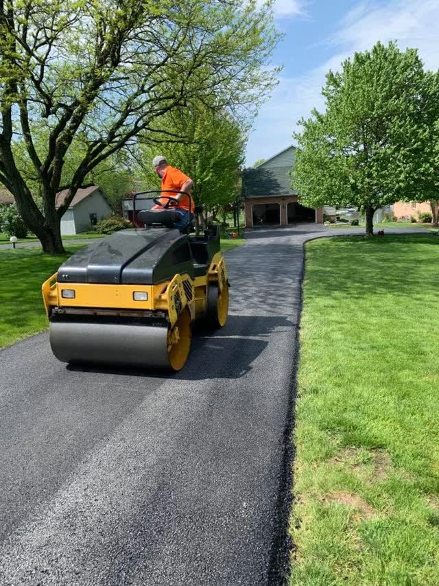 Roller operator compacting a residential driveway