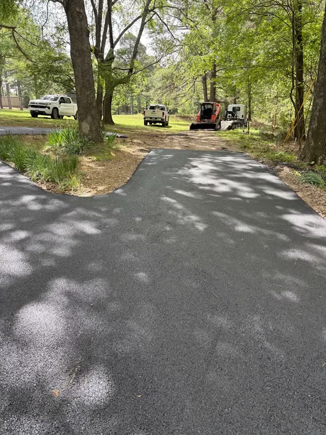 Shaded new driveway with crew trucks in the background