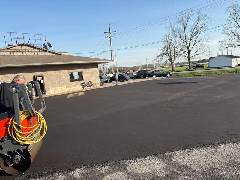 Freshly paved black parking lot in front of a small office building