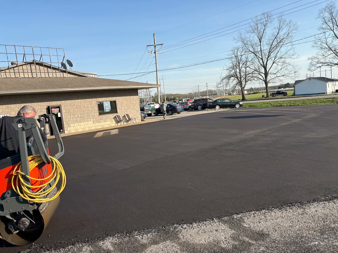 Freshly paved black parking lot in front of a small office building